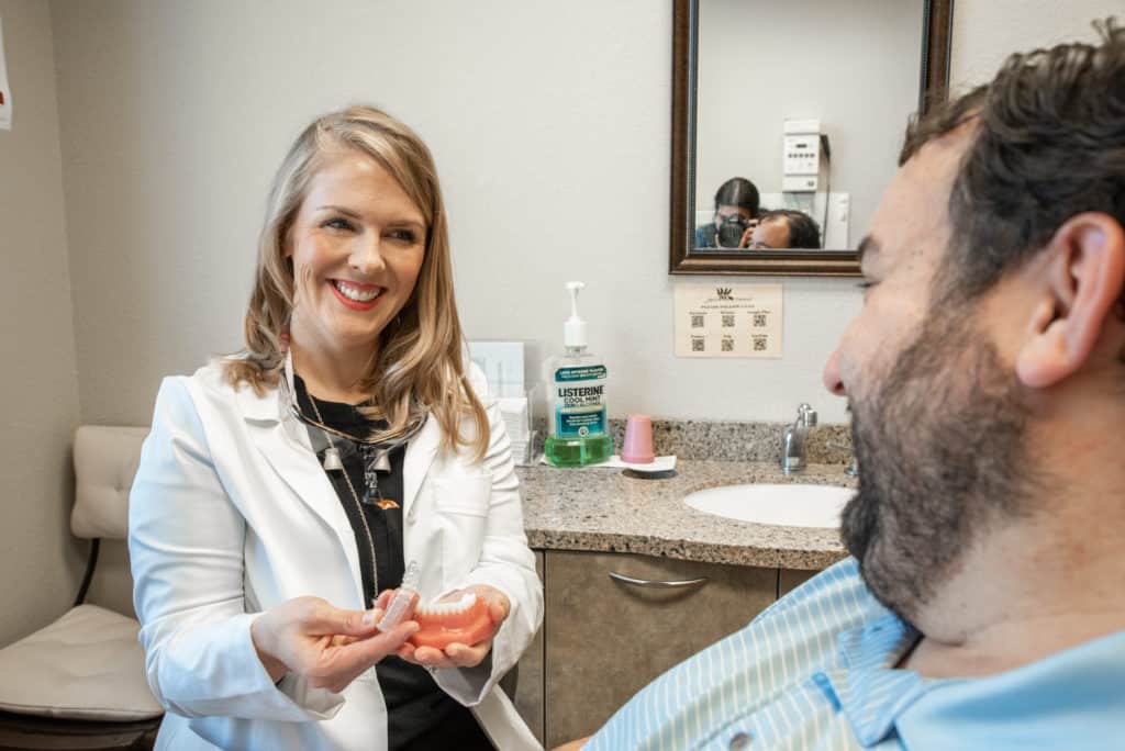cosmetic dentist in Arlington, TX, explaining dental bonding treatment to her patient