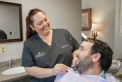 Our emergency dentist in Arlington smiling at a patient after treating his severe toothache.