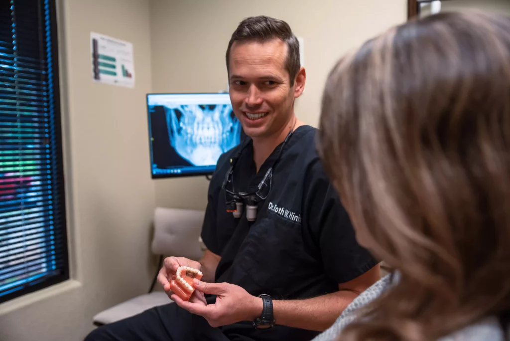 dental implants specialists showing a patient her new teeth