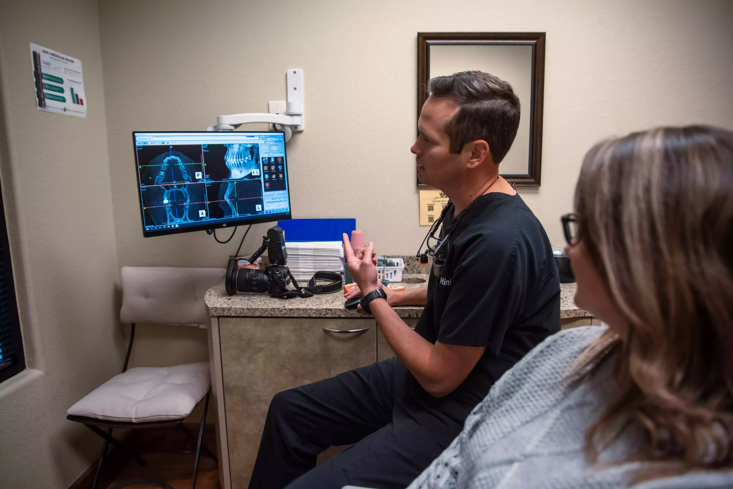 restorative dentist in arlington showing a patient their teeth to prep for dental implants